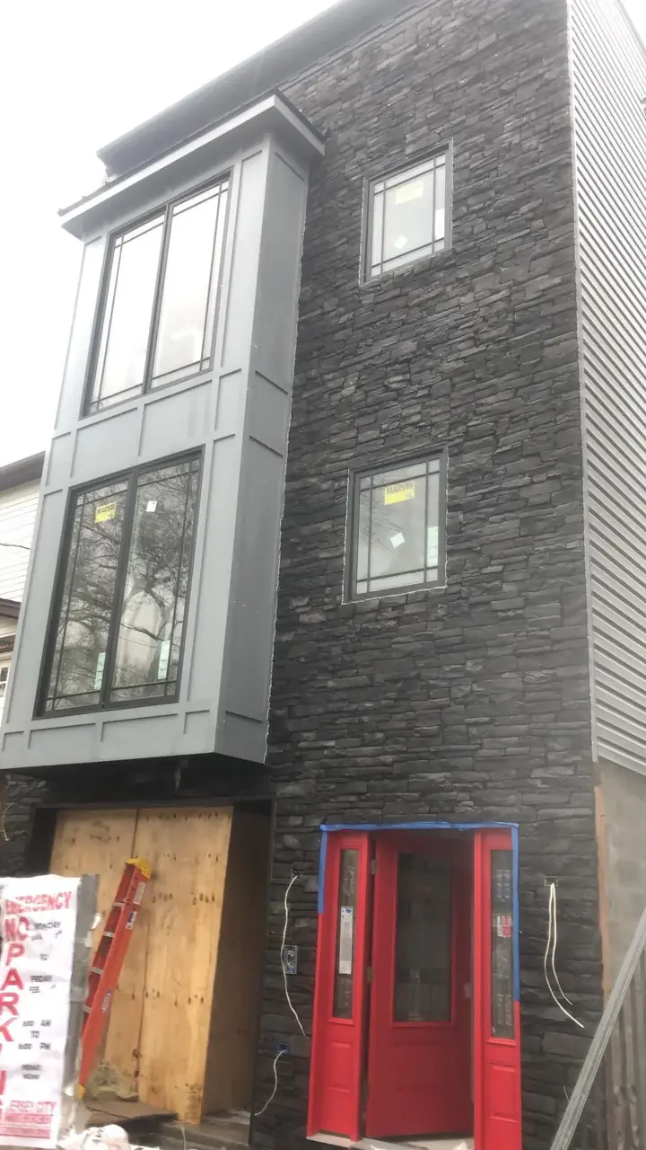 Dark architectural stone facade by JP Wall Worthy Construction